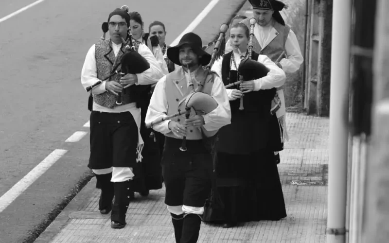 Foto en branco e negro de pasarrúas de grupo tradicional galego Os Chaneiros