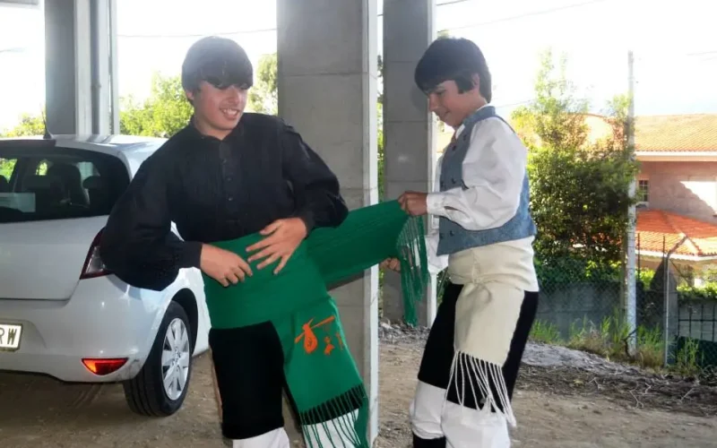 Nenos vestidos de galego apretando a faxa